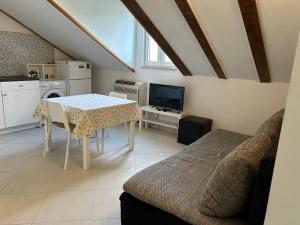 a kitchen and living room with a table and a couch at Rose Garden in Mokošica