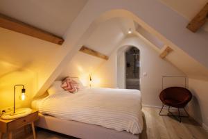 a bedroom with a white bed and a chair at The Edewallenaar in Kortemark +75 photos