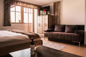 a living room with a bed and a couch at Landhaus am Hügel in Bad Gastein