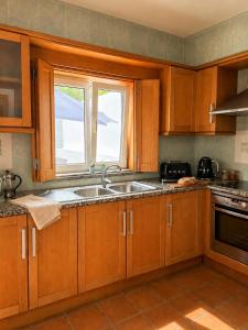 a kitchen with wooden cabinets and a sink and a window at Iconic Vila d'Obidos in Óbidos +6 photos