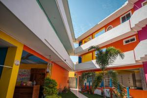 a brightly colored building with a palm tree in front at Happy Beach - Playa Feliz in Ixtapa-Zihuatanejo International