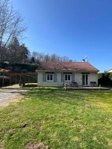 a small white house with a grass yard at La Maison de Miel in Beynat