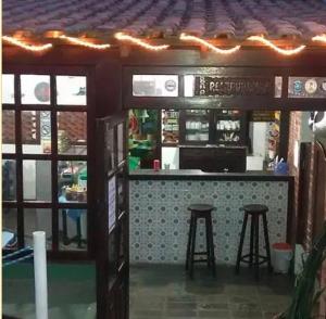 a model of a restaurant with a bar with stools at Pousada Tia Lucia in Saquarema