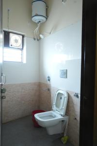 a bathroom with a white toilet and a window at Hotel Hari Sarovar in Kurukshetra