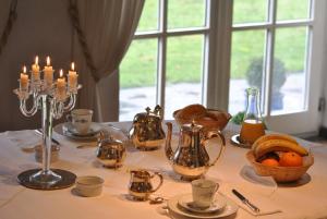 stół ze świecami, garnkami do herbaty i ścierką stołową w obiekcie Aux Cosmos w mieście Olne