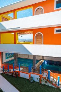 an orange building with a swimming pool at Happy Beach - Playa Feliz in Ixtapa-Zihuatanejo International