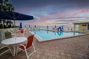 a pool with a table and chairs and an umbrella at Waterfront, Sunset views from balcony, Heated pool in Tampa