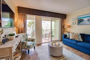 a living room with a blue couch and a table at Waterfront, Sunset views from balcony, Heated pool in Tampa