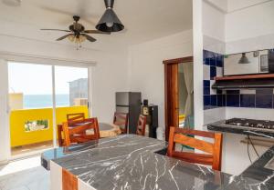 a kitchen with a table and chairs in a room at Happy Beach - Playa Feliz in Ixtapa-Zihuatanejo International