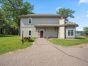 a house with a red door and a bench at Lakefront Gull Lake 2BR Condo Boat Rentals Available Bay Colony 773 in Nisswa