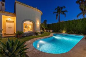 a swimming pool in the backyard of a house at Villa Oliva Nova - Private Pool in Casas Devesa
