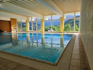 a swimming pool with a view of the mountains at Malejo - HochkönigCard - Pool - Ski-in & Ski-out in Maria Alm am Steinernen Meer