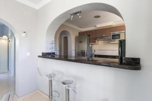 a kitchen with a counter and an archway at Villa Oliva Nova - Private Pool in Casas Devesa