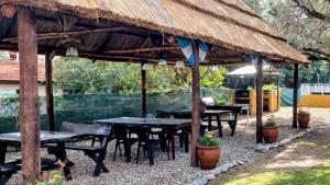 a group of tables and chairs under a roof at Cabañas Pio Pio in Merlo