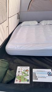 a bed in a tent with two signs on it at StNicholas Ranch Corfu Wild Camping in Benitses