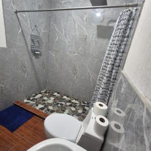 a bathroom with a toilet and two rolls of toilet paper at Estadía Climatizada en Escuintla in Escuintla
