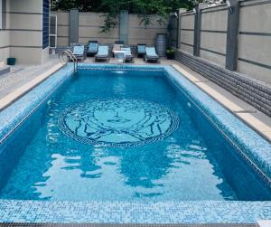 a swimming pool with a medallion in the water at Villa Diamond in Chişinău