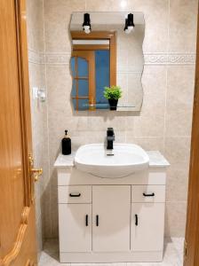 a bathroom with a white sink and a mirror at Precioso apartamento de lujo in Torredembarra +13 photos
