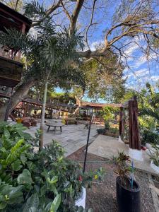 a patio with a picnic table and trees and plants at Pousada Recanto das Chalanas in Corumbá