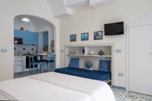 a small bedroom with a bed and a kitchen at Libeccio - flat with terrace and sea view, perfect for up to 3 guests in Maiori