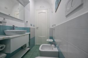 a white bathroom with a sink and a toilet at Libeccio - flat with terrace and sea view, perfect for up to 3 guests in Maiori +27 photos