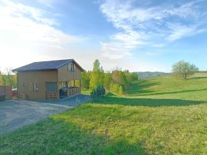 a house in the middle of a grassy field at Leśna Chatka Kotlina Kłodzka in Kłodzko