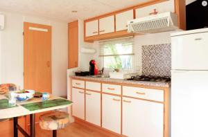 a kitchen with white cabinets and a white refrigerator at St.Nicholas Ranch Corfu in Benitses