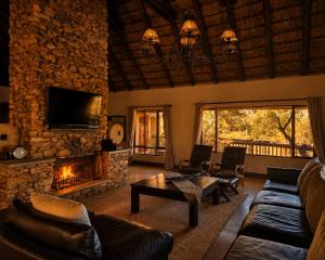 a living room with a couch and a fireplace at Mingwe Private Game Lodge in Mabula