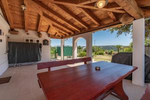 a large wooden table on a patio with a view at House Vila Ana in Lopar