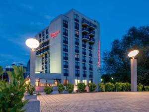 a hotel building with two lights in front of it at Mercure Hotel Saarbrücken City in Saarbrücken