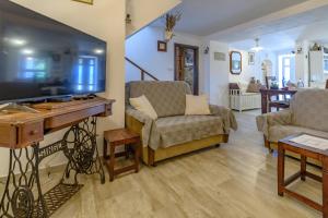 a living room with a tv and a couch and a table at House Vila Ana in Lopar