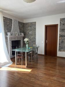 a dining room with a table and chairs and a fireplace at Charming & bright apartment Como lakefront in Argegno