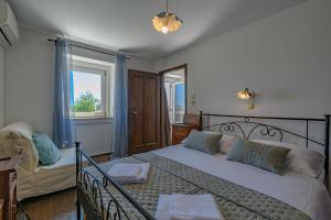 a bedroom with a bed and a couch and a window at House Vila Ana in Lopar