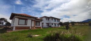 a small white house in a field with a green yard at Casas Villa de Leyva in Villa de Leyva +15 photos