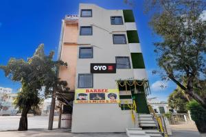 a white building with an oops sign on it at Hotel O Eleven in Jabalpur