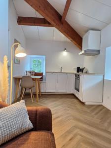 a living room with a couch and a kitchen at Les Gites de la Bastide in Ribes