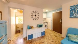 a living room with a blue chair and a microwave at Casa vacanza 'Note di mare' in Torvaianica