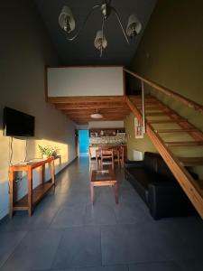 a living room with a staircase and a table and a couch at Centro Apart in Villa Elisa