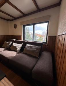 a couch in a room with a large window at Mon Refuge 120 in Bcharré
