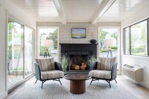 a living room with two chairs and a fireplace at Aspinquid Resort in Ogunquit