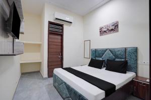 a bedroom with a bed and a television in it at Hotel O The Signature Residency in Rohtak