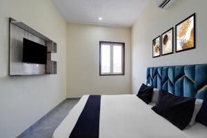 a bedroom with a bed and a tv on the wall at Hotel O The Signature Residency in Rohtak