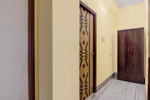 a hallway with a wooden door and a room with a door at Hotel O White Sapphire in Jādabpur