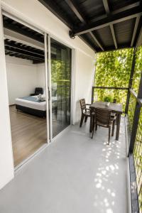 a balcony with a bed and a table and chairs at Carriqui Garden Hotel in Pereira