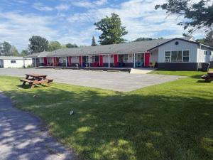 a building with a picnic table in the grass at Nites Inn Motel in Cornwall
