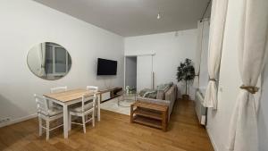 a dining room with a table and a mirror at La bulle dunkerquoise in Coudekerque-Branche
