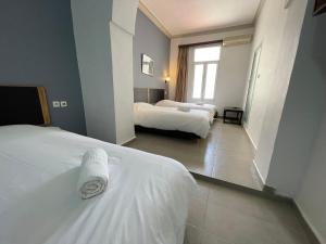 a hotel room with two beds and a window at Hôtel Olympic in Fez +54 photos