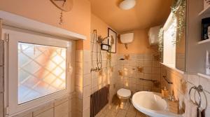 a bathroom with a sink and a toilet and a window at Casa vacanza 'Note di mare' in Torvaianica