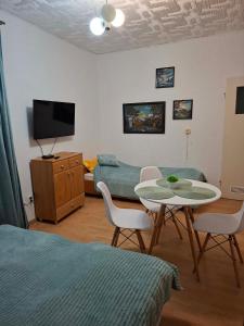 a room with a table and a bed and a tv at Dom Wczasowy Jędrek pokoje in Niechorze
