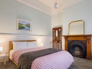 a bedroom with a bed with a fireplace and a mirror at The Fenway Hostel in Launceston +33 photos